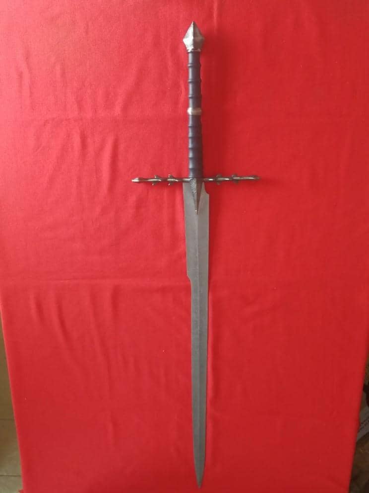 Réplica de la espada de fantasía de los Nazgul de El Señor de los Anillos expuesta en fondo de seda roja. Vendida por Espadas y más