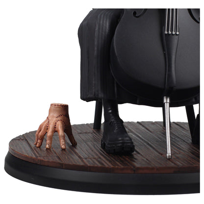 Figura Wednesday y Thing - vista trasera con silla negra y base de madera