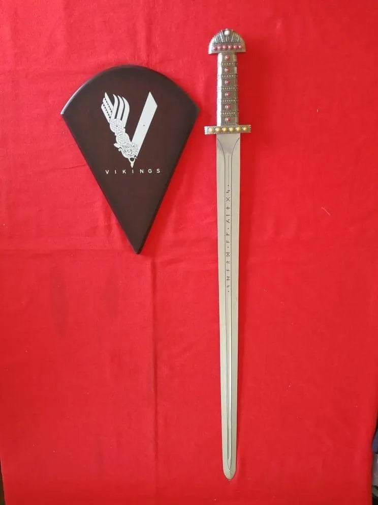 Espada del Rey Ragnar Lothbrok con expositor de la serie Vikingos (Vikings) con fondo rojo. Vendida por Espadas y más