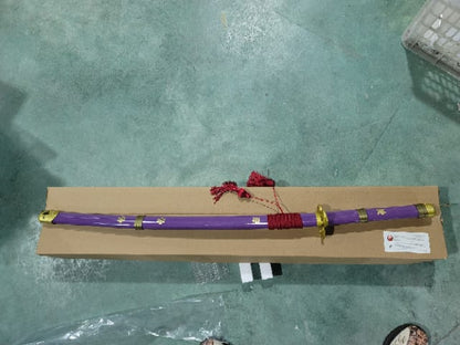 Katana Enma morada de Zoro de One Piece decorativa con saya morada, sageo rojo. Envainada. Vendida por Espadas y más