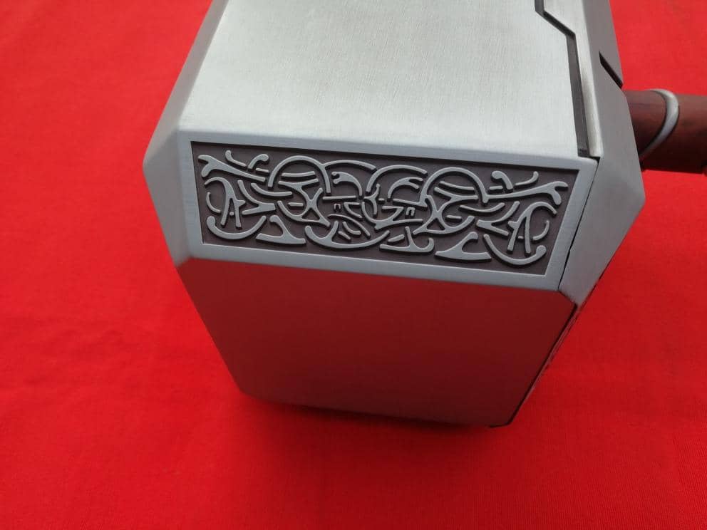 Detalle con grabado de la cabeza del Martillo de Thor Mjolnir de metal de Marvel. Vendido por Espadas y más