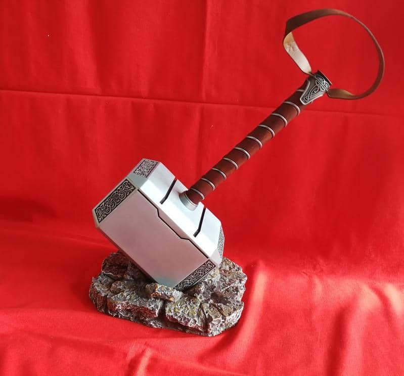 Martillo de Thor Mjolnir de metal de Marvel como el de la película sostenido en simulación de piedra. Vendido por Espadas y más